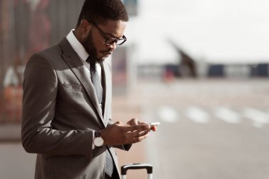 Taksi siparişi. Afro İşadamı Cep Telefonu Uygulaması Kullanma, Havaalanına Varış, Space Kopyala