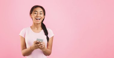 Becerikli alet gelecek. Smartphone cep telefonu ile pembe bir arka plan üzerinde heyecanlı kız manifatura