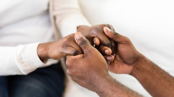 A close-up image of a couples hands clasped together, showcasing their love and connection.