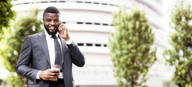 Neşeli Afrikalı İşadamı Kahve Having Ve Cep Telefonu Açık Konuşma.