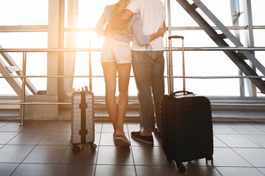 Seyahat konsepti. Uluslararası havaalanı terminalinin penceresine yakın bir yerde sarılan çift, arka görüş, kopyalama alanı