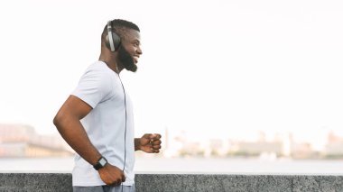 Kulaklık takan bir adam şehrin rıhtımında koşuyor..