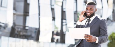 Telefon görüşmeleri. Afrikalı Girişimci Şehir Bölgesi 'nde Durmakta Olan Cep Telefonu Tutma Belgeleri ve Belgeleri Hakkında Konuşuyor. Boşluğu Kopyala, Panorama