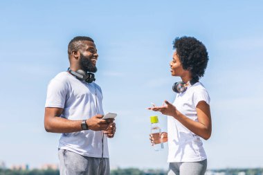 Koşu Koçu Konsepti. Mutlu siyah çift şehirdeki River Bank 'ın yakınındaki Sabah Koşusu Eğitim Planını konuşuyor..