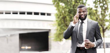 Resmi takım elbiseli bin yıllık adamın portresi kahve içmek ve cep telefonu kullanarak açık havada, kopya alanı