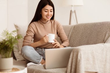 Happy Girl Rahat Kanepede Rahatlatıcı ve Evde Laptop Kullanma, İnternet Sörf