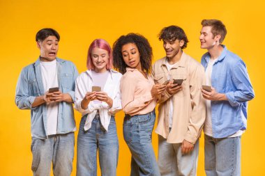 Farklı görünümlü beş genç yetişkinden oluşan bir grup, parlak sarı bir arka plana karşı birlikte dururlar. Hepsi akıllı telefonlarına değişik ifadelerle bakıyor.