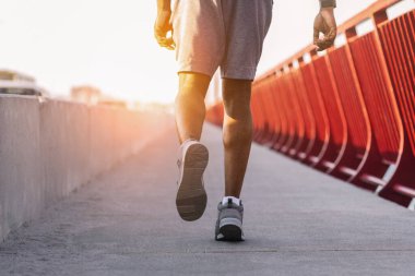 Köprüde koşan atletik siyah adamın bacakları Güneş patlaması, kopyalama alanı
