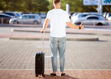 Eve Dönüş Konsepti. Taksiye yetişmeye çalışan turistler, bavullarıyla ayakta duruyorlar ve başparmaklarını gösteriyorlar, telif alanı, arka plan