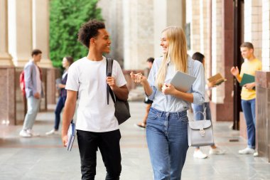 Mola ve iletişim sırasında üniversite kampüsünde yürüyen çok ırklı öğrenciler, kopya alanı