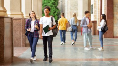 Mutlu üniversite sınıf arkadaşları mola sırasında kampüste yürüyüş ve iletişim, kopya alanı