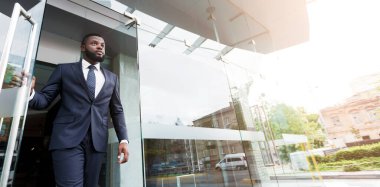 Yakışıklı afro-amerikan ceo ortakları ile görüştükten sonra modern iş merkezinden ayrılıyor. Düşük açılı çekim