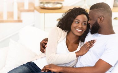 Bir çift evdeki kanepede dinleniyor, birbirlerine sevgi dolu bakışlar atıyorlar..