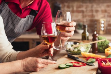 Bir çift, mutfaklarında yemek hazırladıktan sonra bir bardak şarabın keyfini çıkarırken görülüyor. İkisi de gülümsüyor ve birbirlerine eşlik etmekten zevk alıyorlar. Mutfak tezgahı malzemelerle dolu.