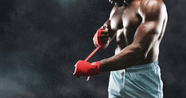 Kaslı bir boksör ellerini sıkı bir dövüşe hazırlıyor..