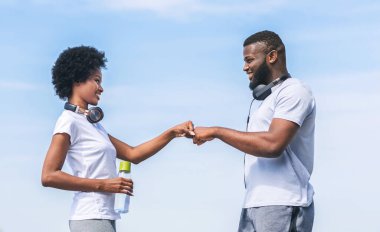 Sabah koşusu. Siyah adam ve kadın nehir boyunca koştuktan sonra yumruk tokuşturuyorlar..