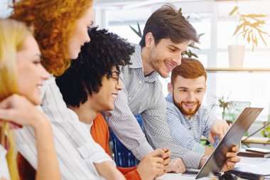 Yeni iş planı. Genç neşeli insanlar coworking işyerinde pano bakarak, boş alan