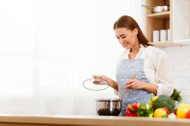 Milenyum Kadını Mutfakta Yemek Pişiriyor, Tahta Kaşıkla Çorba Karıştırıyor, Boşluğu Kopyala