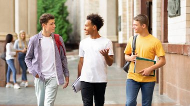 Üniversite hayatı. Kampüste yürüyen ve dışarıda sohbet eden adamlar.
