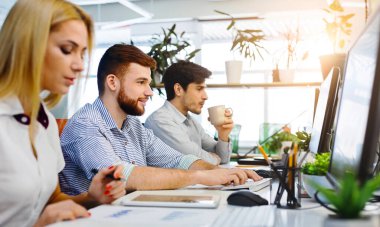 Çalışma ofisinde bilgisayarlarda çalışan genç milenyal insanlar, boş alan