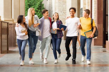 Başarılı testler. Üniversite kampüsünde yürüyen ve dışarıda sohbet eden öğrenciler