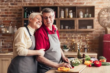 Modern mutfakta aşçısını kucaklayan mutlu, yaşlı çifti seven, birlikte vakit geçiren, özgür bir yer.