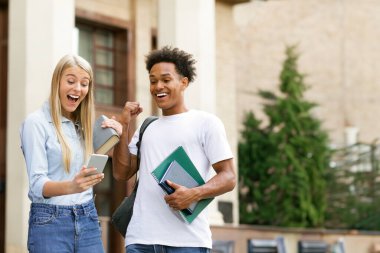 Mükemmel notlar. Şaşırmış öğrenciler akıllı telefondan sınav sonuçlarını kontrol ediyorlar.