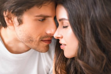 Bu, öpüşmek üzere olan bir erkekle bir kadının yakın plan portresi. Birbirlerinin gözlerinin içine bakıyorlar ve birbirlerine aşık gibi görünüyorlar..