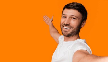 Şuna bak. Pozitif Adam Selfie alarak ve Yellow Studio arka plan üzerinde boş alanda gösteren.