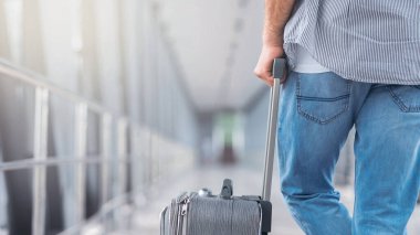 Havaalanında. Terminal geçitte bekleyen, uçuşa hazırlanan bagajı olan adam, boş alan
