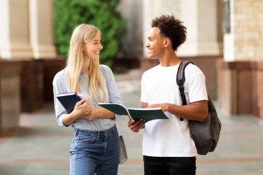 Öğrenciler sohbet ediyor, üniversite kampüsünde sınıflar arasında geziniyor, fotokopi çekiyor.