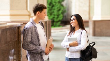 Dersten sonra ara veren, üniversite kampüsünde konuşan ve flört eden öğrenci çift