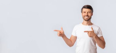 Şuna bak. Gülümseyen adam Beyaz Stüdyo arka plan üzerinde kenara parmaklarını işaret. Boş Alan