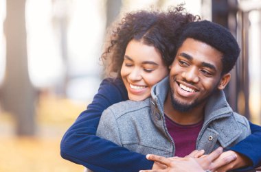 Sonbahar parkta tarih iken Lovely genç siyah çift sarılma, uzay kopyalamak