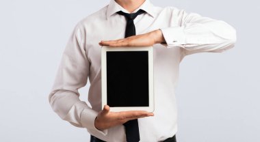 İş Uygulaması. Studio Beyaz Arka Plan üzerinde boş tablet bilgisayar ekranı gösteren neşeli adam. Mockup