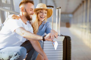 Akıllı telefon kullanarak havaalanında heyecanlı çift, gezi arama, kalkış, boş alan bekliyor