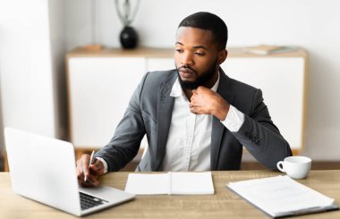 Modern ofis içinde çalışan, kendine güvenen siyah iş adamının portresi.