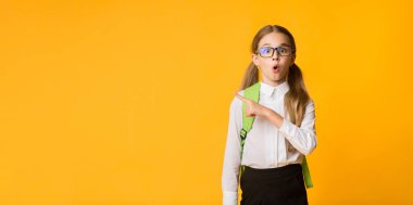 Vay canına, şuna bak. Şok Schoolgirl Studio Sarı Arka Plan Kenara Parmak İşaret. Metin için boş alan içeren panorama