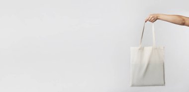 Kadın El Gri Stüdyo arka plan üzerinde beyaz boş eko çanta tutan. Ekoloji Ve Minimalizm Kavramı