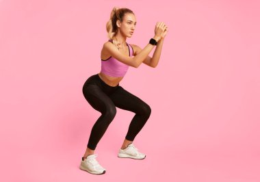 Egzersiz. Genç kadın Sarı Stüdyo arka plan üzerinde derin squat egzersiz yapıyor. Kopyalama Alanı