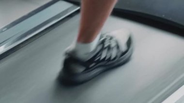 Egzersiz programından önce ısın. Koşu bandında yavaş kardiyo dayanıklılığı egzersizi yapan adama yaklaş.