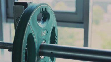 Güç kaldırma egzersizi. Sporcu spor salonunda egzersiz yapmadan önce halterlere ağırlık plakası ekliyor. Kapatın.