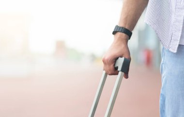 Vardıktan sonra. Havaalanının dışında duran, nakil mekiği, seçici odak noktası, kopyalama alanı bekleyen bavullu erkek gezginin kesilmiş resmi.