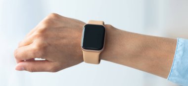 Kesilmiş kadın eli görüntüsünü kapat. Akıllı saat, siyah boş ekran, seçici odak, bulanık arka plan. Smartwatch - boş ekranlı modern dijital aygıt, boşluğu kopyala