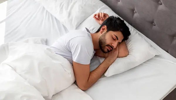 Stock image Asleep young arab man sleeping, resting peacefully in comfortable bed, lying with closed eyes, free space. Recreation, deep male sleep, time to rest and nap concept