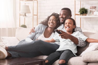 Mutlu Afro-Amerikan ailesi evde televizyon izleyip hafta sonunun tadını çıkarıyor..