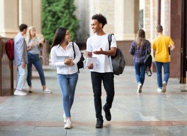 Üniversite kampüsünde mola ve konuşma sırasında yürüyen mutlu farklı öğrenciler, kopya alanı