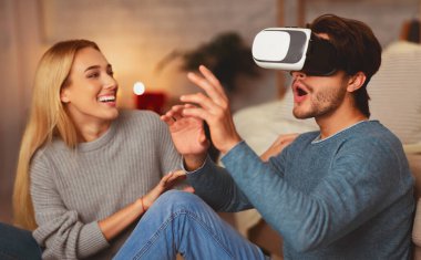 Heyecanlı Erkek Arkadaş ve Kız Arkadaş Sanal Gerçeklik Kulaklığını İçerde Otururken Kullanıyor. VR ve Modern Evde Kalma Tarihi Konsepti