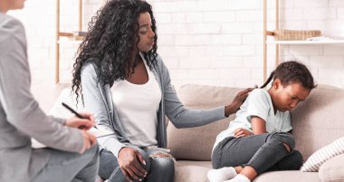 Sorunlu çocuk. Afrika kökenli Amerikalı anne, asi kızını psikolog muayenesinde yatıştırıyor.