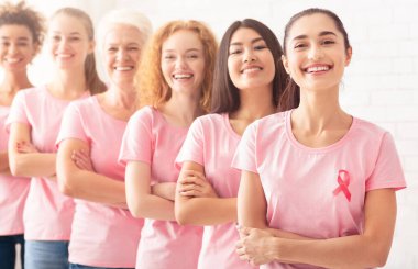 Göğüs kanseri. Onkoloji Farkındalığı olan pembe tişörtlü çok kültürlü kadınlar beyaz arka planda kuyrukta bekliyor. Seçici Odaklanma